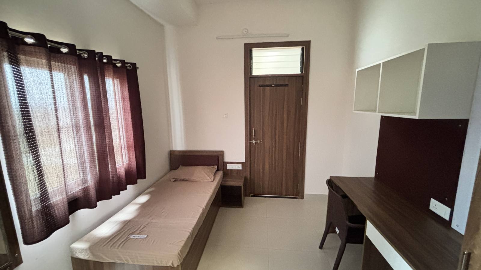 Single room with bed, desk and door